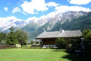 eine Hütte auf einem Feld mit Bergen im Hintergrund in der Unterkunft Résidence Beauregard - Beauregard 6 MAE-6421 in Les Houches