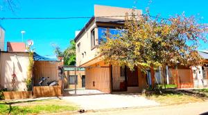 a house with a tree in front of it at Alojamientos La Martina in Colón