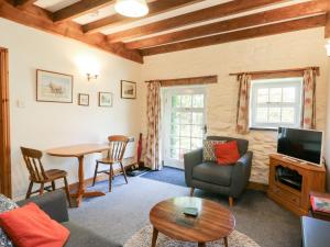 a living room with a couch and a table at Royal Oak Farm Cottage in Betws-y-coed