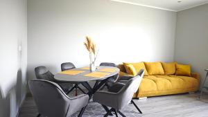 a dining room with a table and a yellow couch at DANESSI-Familie,Business,nahe Koblenz,6 Personen,Saniert,direkte Anbindung Industriegebiet,TV Kingsize Boxspringbett in Mülheim-Kärlich