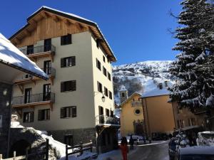 un edificio en la nieve al lado de un árbol en Résidence Les Etoiles Des Neiges - 4 pièces 6 personnes exposé Ouest MAE-7854, en Valloire