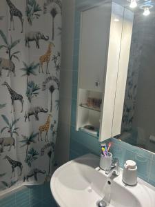 a bathroom with a sink and a shower curtain with giraffes at Sunset View Maisonette, Kanali in Néa Thésis +27 photos