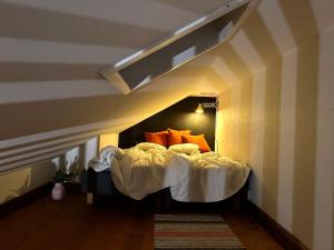 a bed with orange pillows in a room at Kalmar City in Kalmar