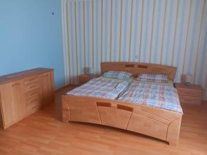 a bedroom with a wooden bed and a dresser at Hunsrücktraum in Mittelstrimmig