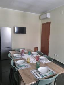 a dining room table with plates and glasses on it at Appartamento a Ponente in Massafra