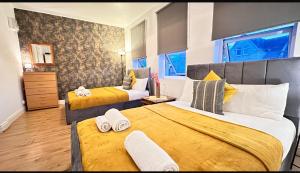 a hotel room with two beds and a window at Entire Flat in FINCHLEY ROAD in London
