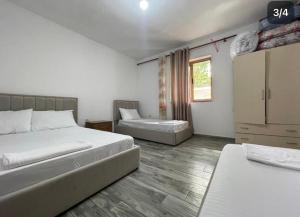 a bedroom with two beds and a chair in it at Thethi Mountain guesthouse in Theth