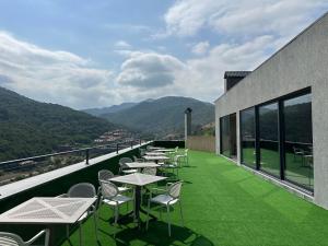 a row of tables and chairs on a balcony with mountains at Level 8 Dilijan in Dilijan