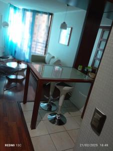 una mesa de cristal en una sala de estar con una silla en Apartamentos Isaurys, en Santiago