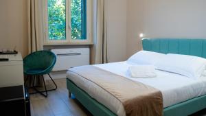 a bedroom with a bed and a chair and a window at Suites 215 Colosseum - Guesthouse in Rome