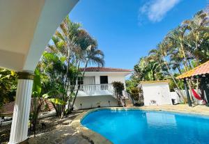 a swimming pool in front of a house at HappiCasaRD & Holistic House in Sosúa +29 photos