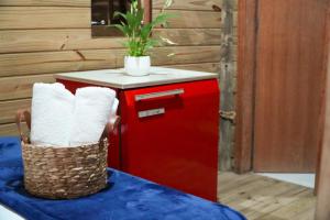 a red refrigerator with a basket on a table at Pousada Prazeres do Rosa in Imbituba
