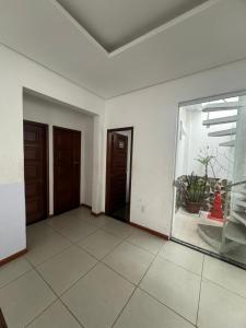una habitación vacía con dos puertas y una ventana en casatemporadabelem, en Belém