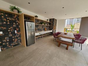 a dining room with a table and a refrigerator at Today Perdizes - Novo e sofisticado, em frente ao Allianz Parque in Sao Paulo