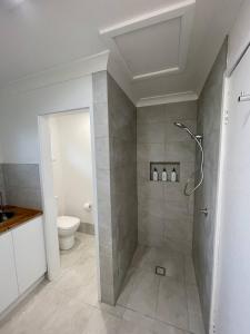 a bathroom with a shower and a toilet at Sea Salt One Burgess Beach in Forster +5 photos