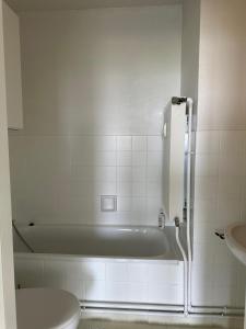 un bagno bianco con vasca e WC di Studio Knokke-Heist a Knokke-Heist 1 altra foto