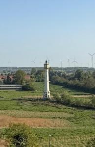 un faro in mezzo a un campo di Studio Knokke-Heist a Knokke-Heist
