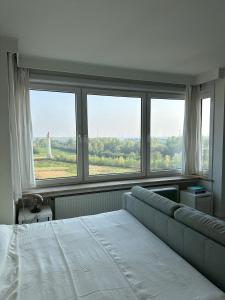 una camera da letto con un letto e una grande finestra di Studio Knokke-Heist a Knokke-Heist