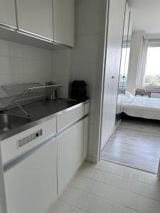una cucina bianca con lavandino e letto di Studio Knokke-Heist a Knokke-Heist