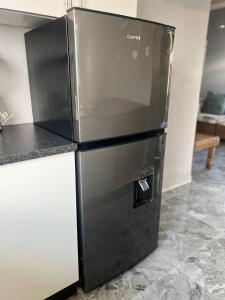 a black refrigerator sitting in a kitchen at Inala Urban Guesthouse in Bulawayo +4 photos
