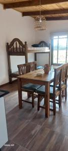 a dining room with a wooden table and chairs at Portezuelo de árboles in Panaholma