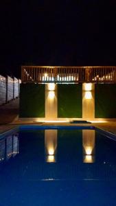a swimming pool at night with lights around it at La Casa Bella De Lunahuana in Lunahuaná