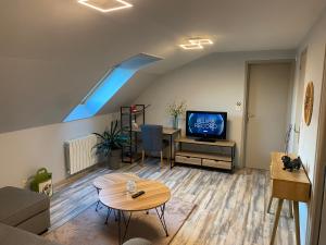 a living room with a couch and a tv and a table at Appartement centre ville in Ussel