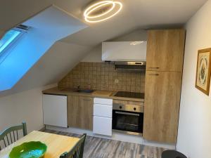 a kitchen with white cabinets and a wooden table at Appartement centre ville in Ussel