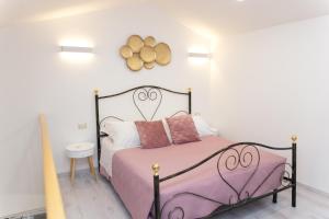 a bedroom with a black and white bed with pink sheets at 3 Rooms - Perla private loft with jacuzzi in Catania