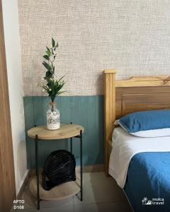a bedroom with a bed and a table with a plant on it at Gran Alojamiento Familiar con 4 Piscinas y Jacuzzi - Para 13 personas - By Molca Travel in Armenia
