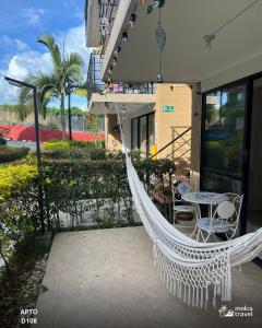 a hammock on a balcony with a table and chairs at Gran Alojamiento Familiar con 4 Piscinas y Jacuzzi - Para 13 personas - By Molca Travel in Armenia