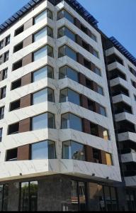 a tall building with windows on the side of it at Skopje Stefanovi apartments in Skopje