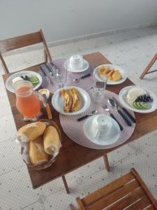 einen Tisch mit Teller mit Essen und Brot darauf in der Unterkunft Pousada Rainha do Mar in Ilha de Boipeba