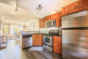 a kitchen with wooden cabinets and a stainless steel refrigerator at Alpine Oasis at Alpine Village in Canmore +43 photos