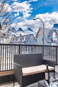 a bench on a balcony with a view of mountains at Alpine Oasis at Alpine Village in Canmore