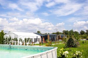 a swimming pool in a yard with a building at Ostoja Czersk Zamek Góra Kalwaria in Czersk
