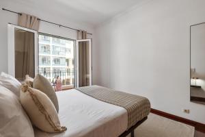 a bedroom with a bed and a large window at Doca's Refuge by Homie in Ilhéu do Gorgulho