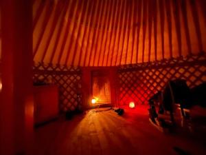 a room with a wooden floor and a red light at Jurte für naturliebhaber in Dernbach