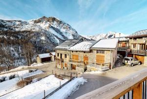 een luchtzicht op een gebouw met besneeuwde bergen bij Chalet De Manou - Chalet individuel rénové avec sauna dans les 3 Vallées MAE-3694 in Saint-Martin-de-Belleville