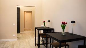 two black tables with flowers on them in a room at Suites 215 Colosseum - Guesthouse in Rome +26 photos