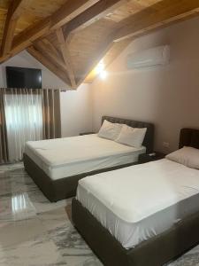 two beds in a hotel room with at Guest house Andersoni Dhoma plazhi Andersoni in (( Shën Ded Gjoni ))