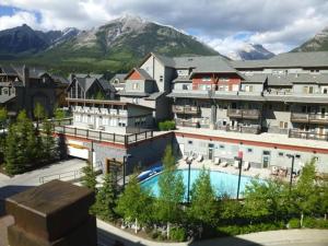 a resort with a swimming pool in front of a mountain at Alpine Vista - Family Fun Pool & Hot Tub in Canmore