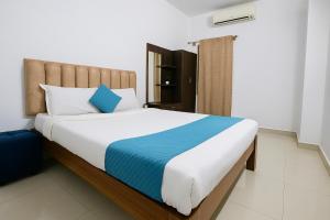 a bedroom with a large bed with blue and white pillows at Cozy retreat in Mysore