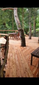 a wooden deck with benches and a tree at Jurte für naturliebhaber in Dernbach