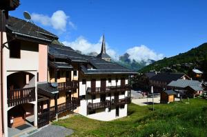 a building with a steeple in a village at Résidence Biolley 1 - Studio pour 2 personnes dans le centre du village MAE-4274 in Saint-Martin-de-Belleville