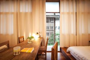 ein Zimmer mit einem Holztisch mit einem Bett und einem Fenster in der Unterkunft Mana Craft Stay in Bangkok