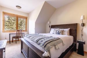 a bedroom with a bed and a desk and a window at Creekside at Rundle Cliffs Lodge in Canmore