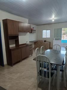 a kitchen and dining room with a table and chairs at Recanto Paraíso in Rio Piracicaba