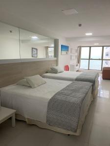 a bedroom with two beds and a mirror at Beach Class Executive Flat na Beira Mar de Boa Viagem in Recife