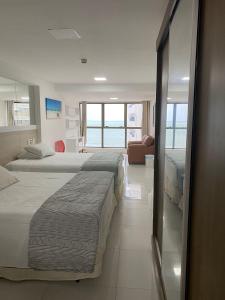 a hotel room with two beds and a view of the ocean at Beach Class Executive Flat na Beira Mar de Boa Viagem in Recife